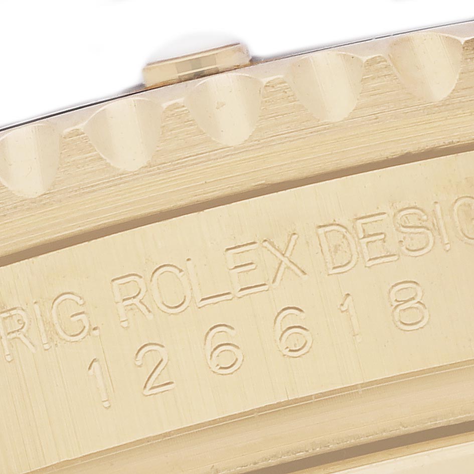 The image shows a close-up of the bezel and engraved design number on a Rolex Submariner 126618 Men's Yellow Gold Black Dial watch.